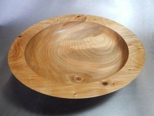 A large wooden bowl is sitting on a table.