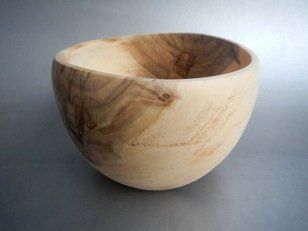 A small wooden bowl is sitting on a table.