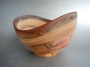 A wooden bowl is sitting on a table.
