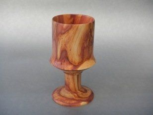 A wooden wine glass is sitting on a table.