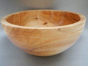 A wooden bowl is sitting on a gray surface