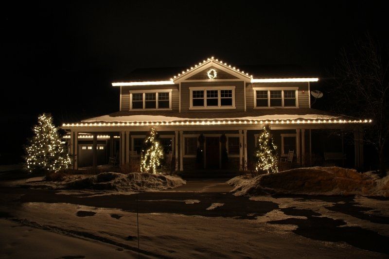 A large house is lit up with christmas lights at night.