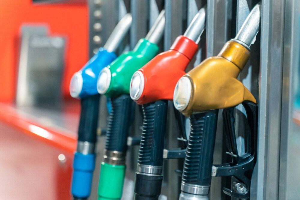A Row Of Gas Pumps Of Different Colors Are Lined Up In A Gas Station — Camden Haven Tyre & Brake Centre In Laurieton, NSW