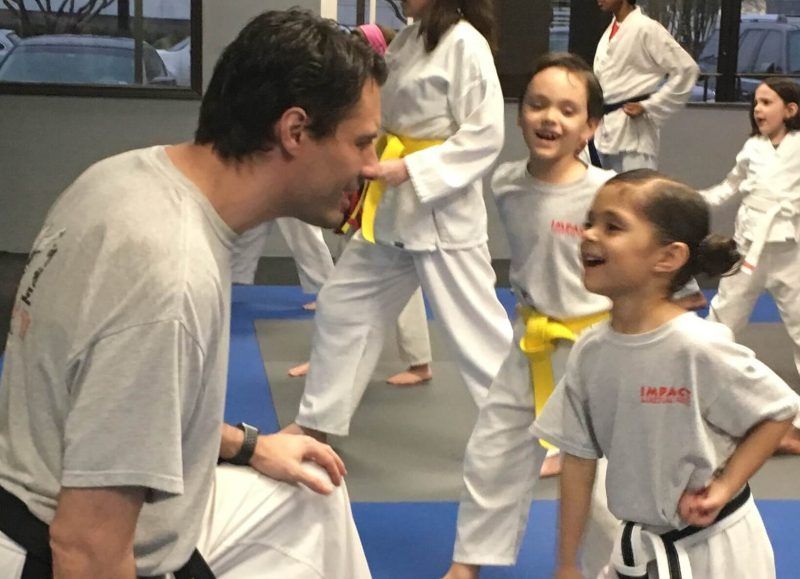 Martial arts instructor teaching a young yellow belt girl