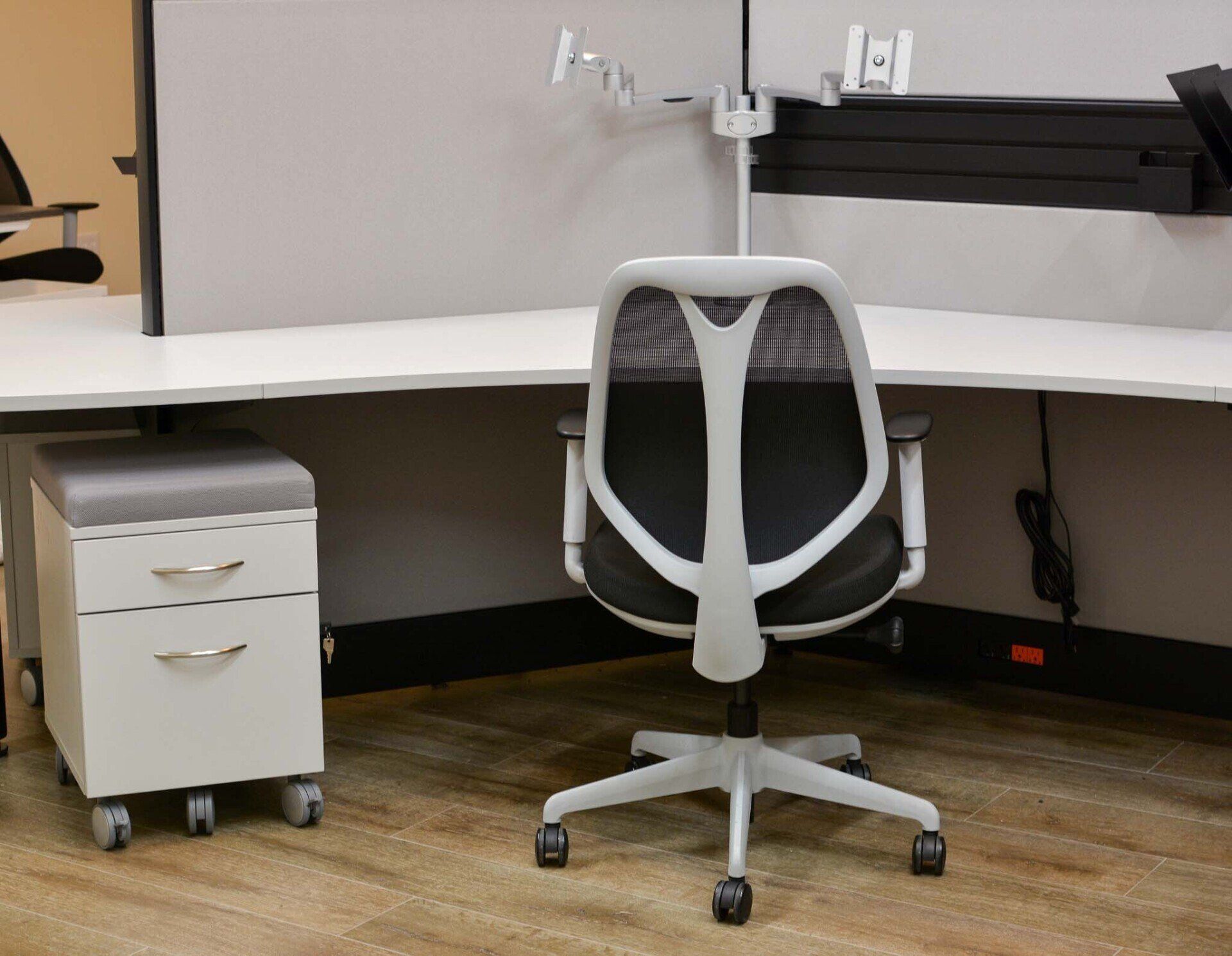 a black and white office chair sits in front of a white desk
