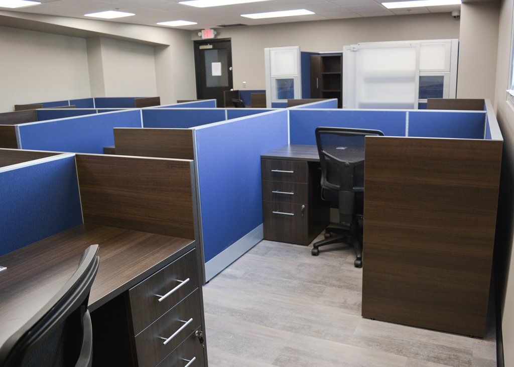 a row of cubicles in an office with blue dividers