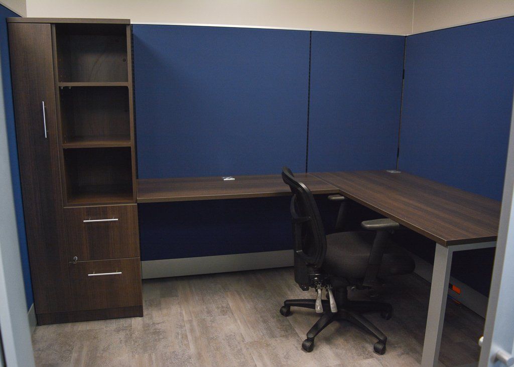 a small cubicle with a desk and a chair