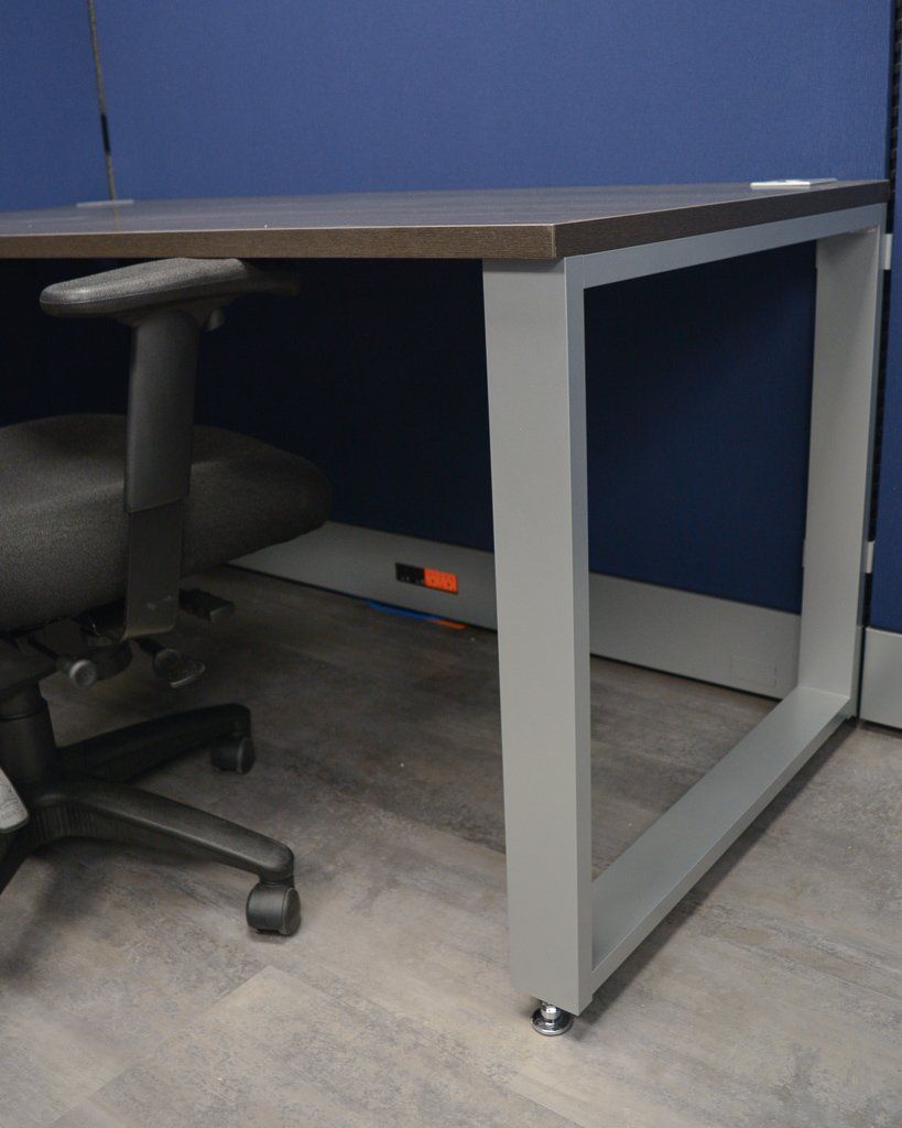 a black office chair sits under a desk with a gray frame
