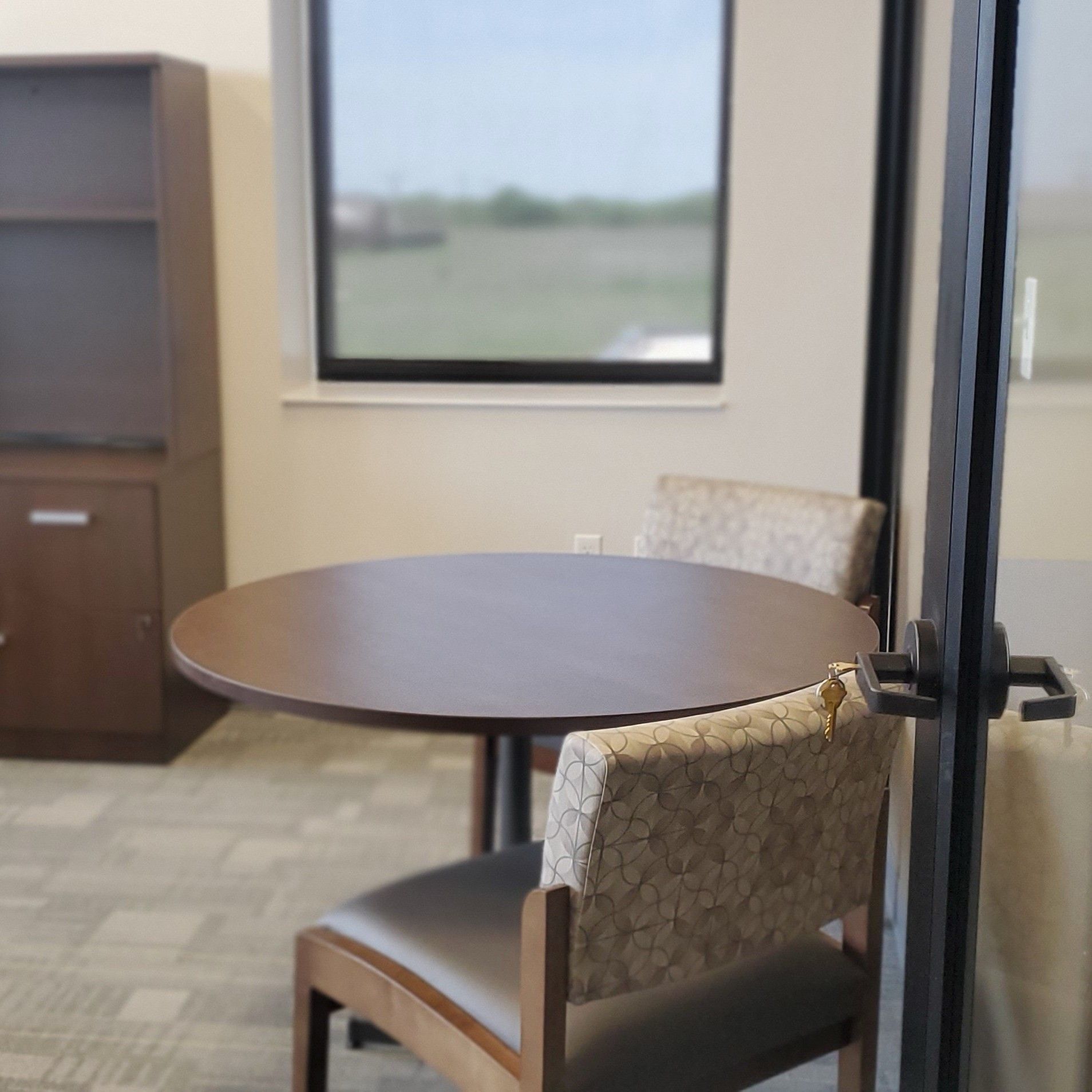 A blue couch and a black coffee table in a small office reception area.