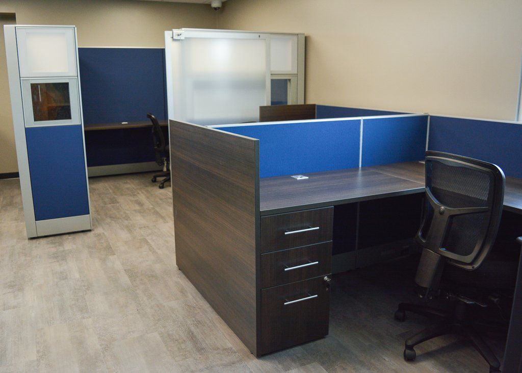 a cubicle with a desk and a chair in it
