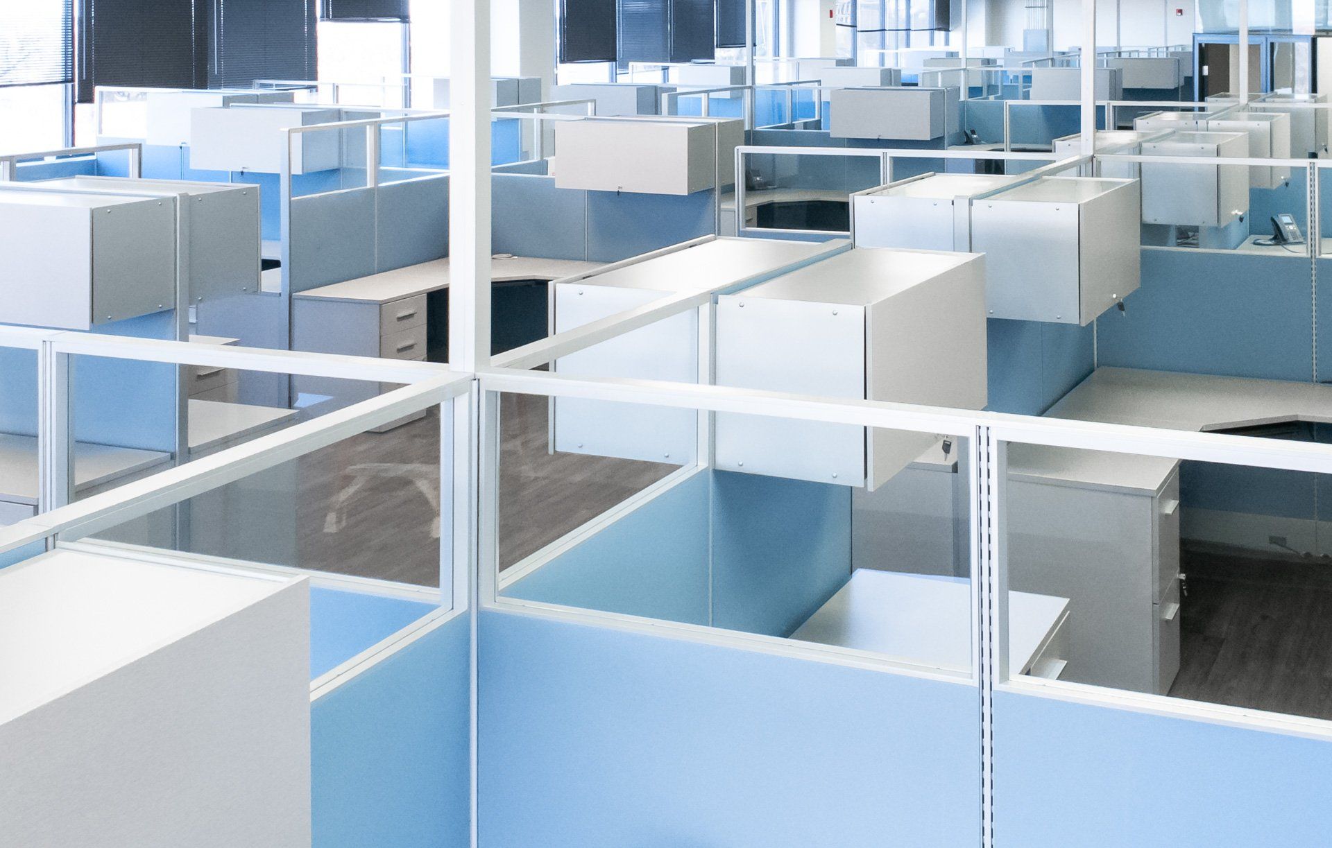 a row of blue and white cubicles in an office
