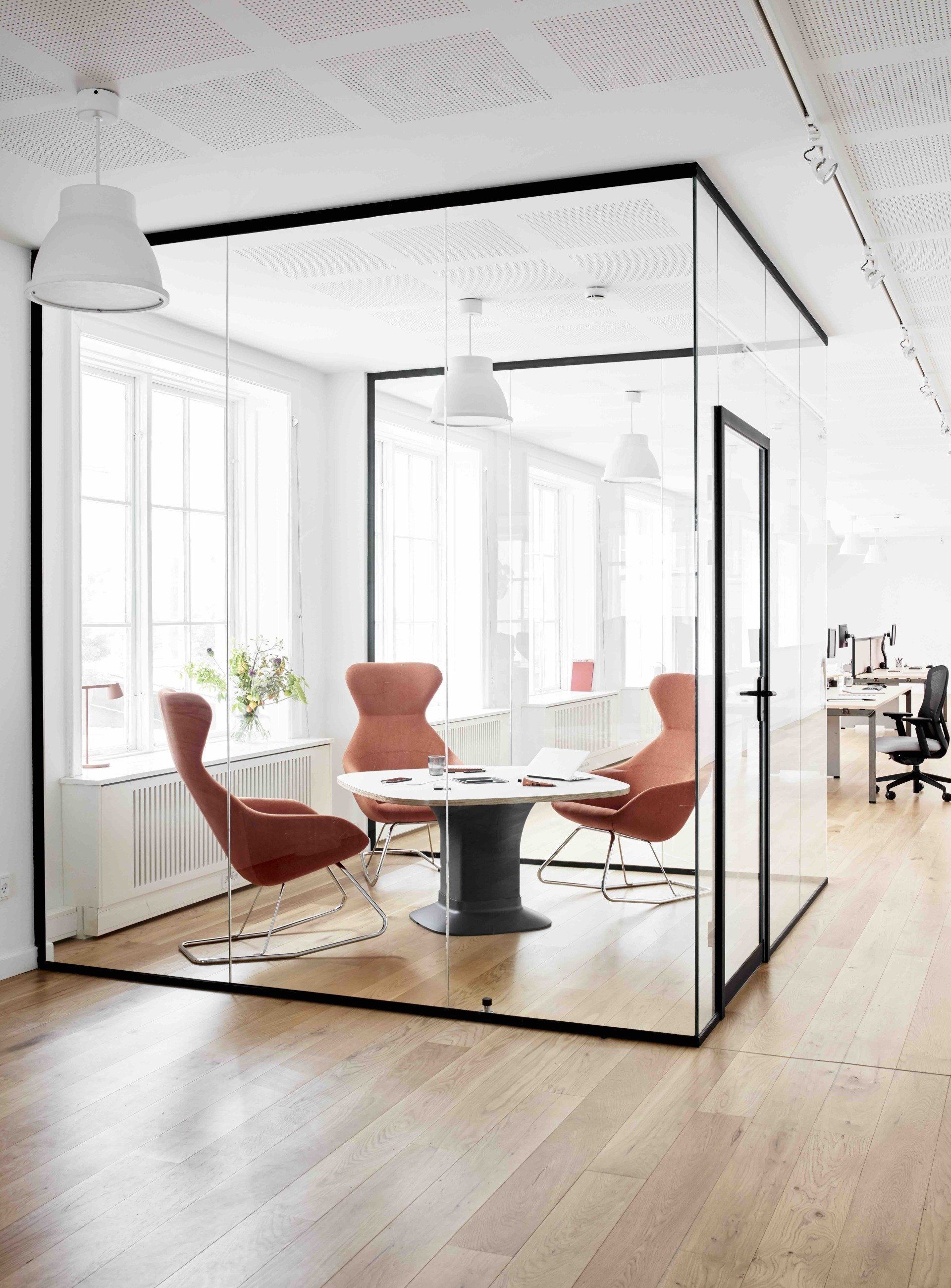 a glass room with chairs and a meeting table in it