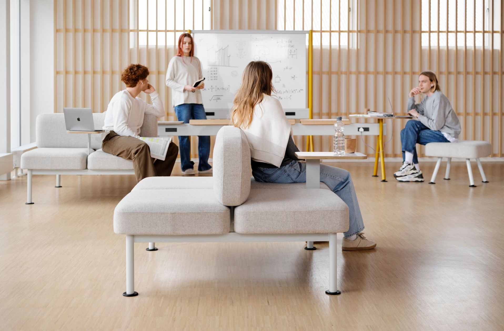 a blurred image of people walking in a room with chairs and ottomans