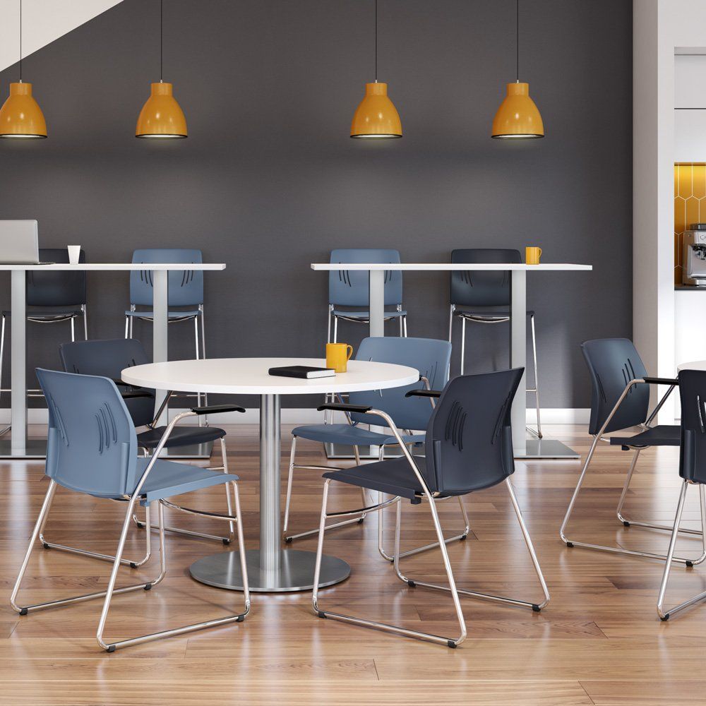 a room with tables and chairs with a yellow light hanging from the ceiling