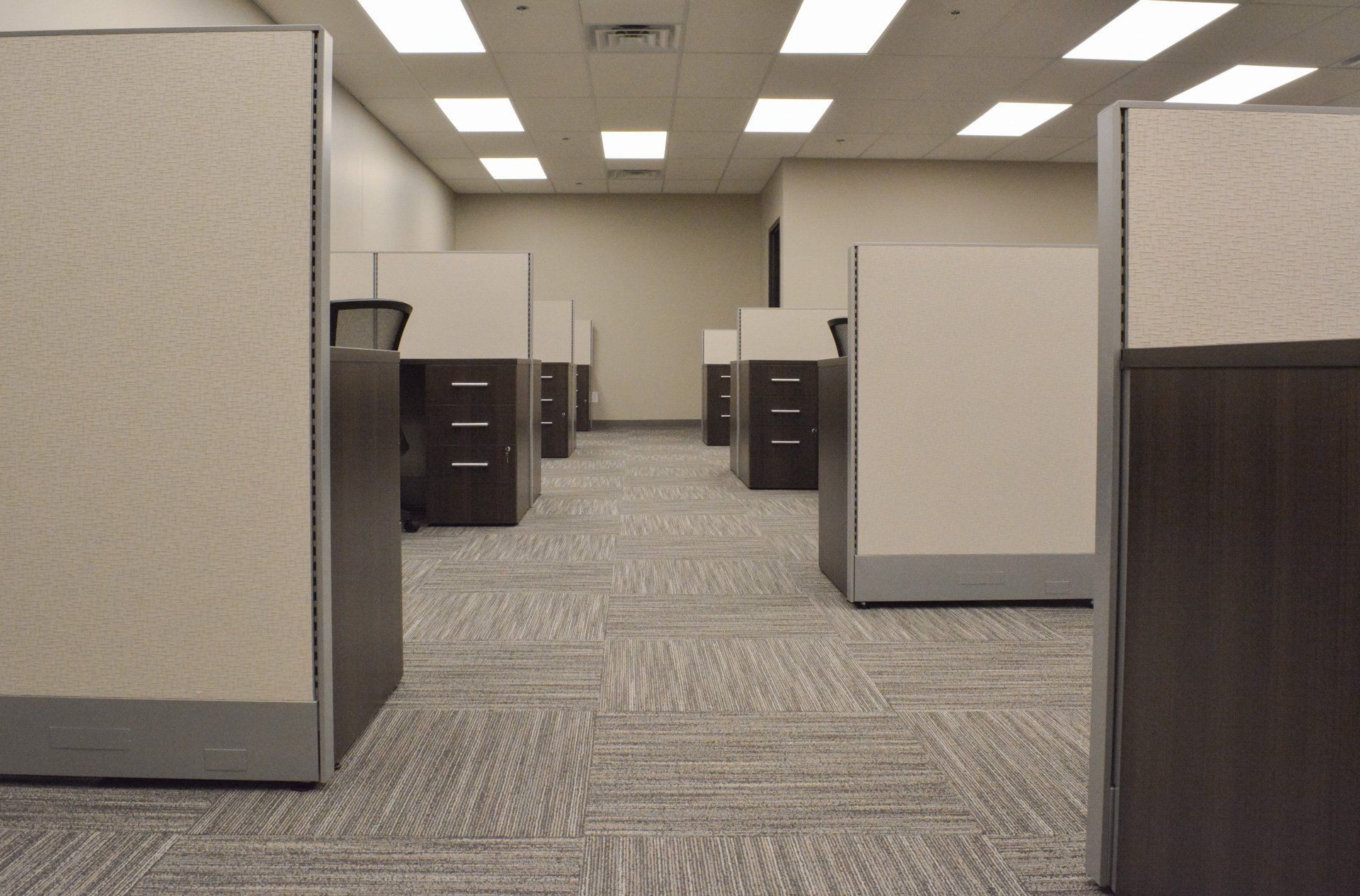 a row of cubicles in an office with a carpeted floor