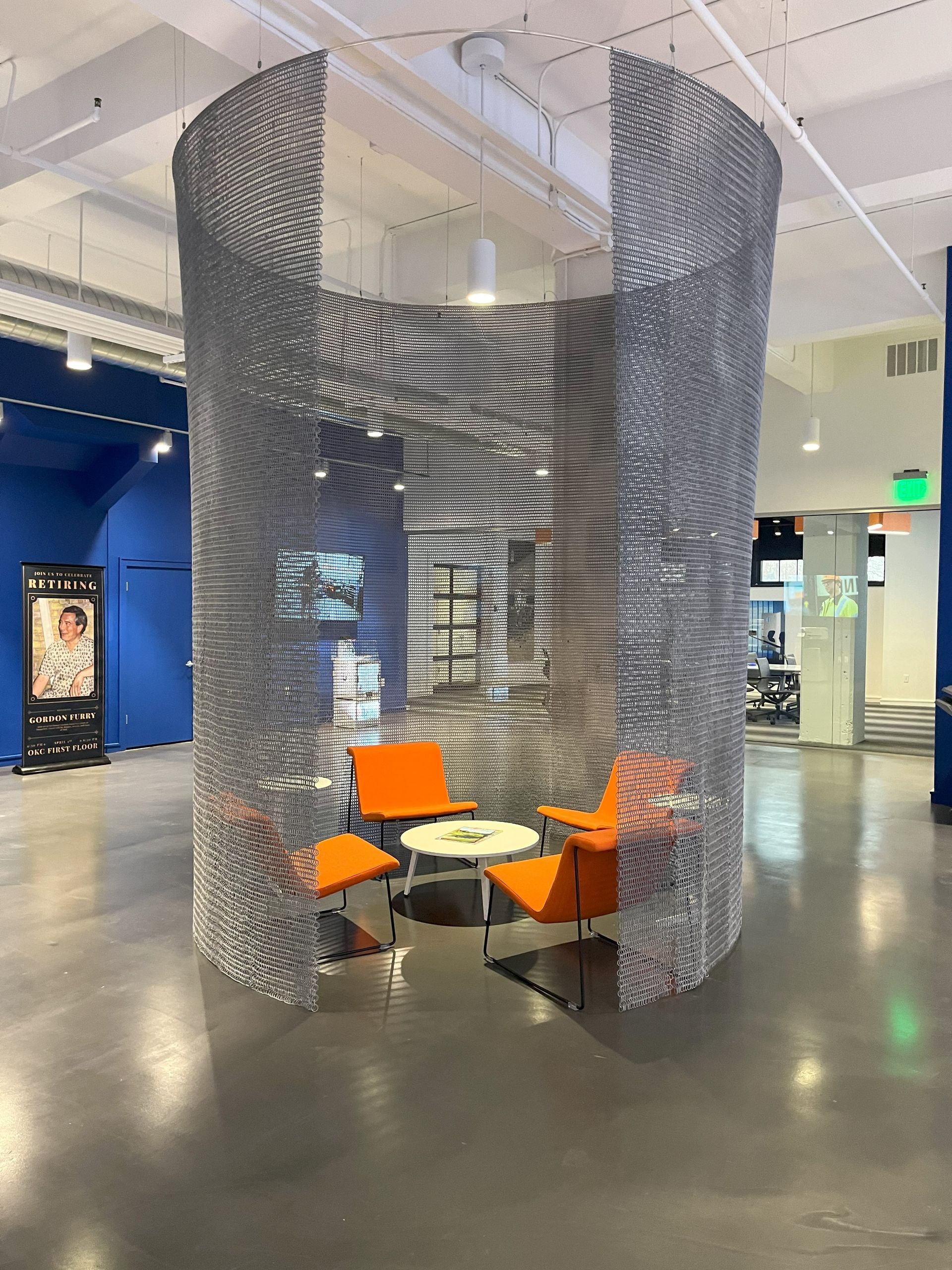 A round meeting space with lounge chairs and a table in it