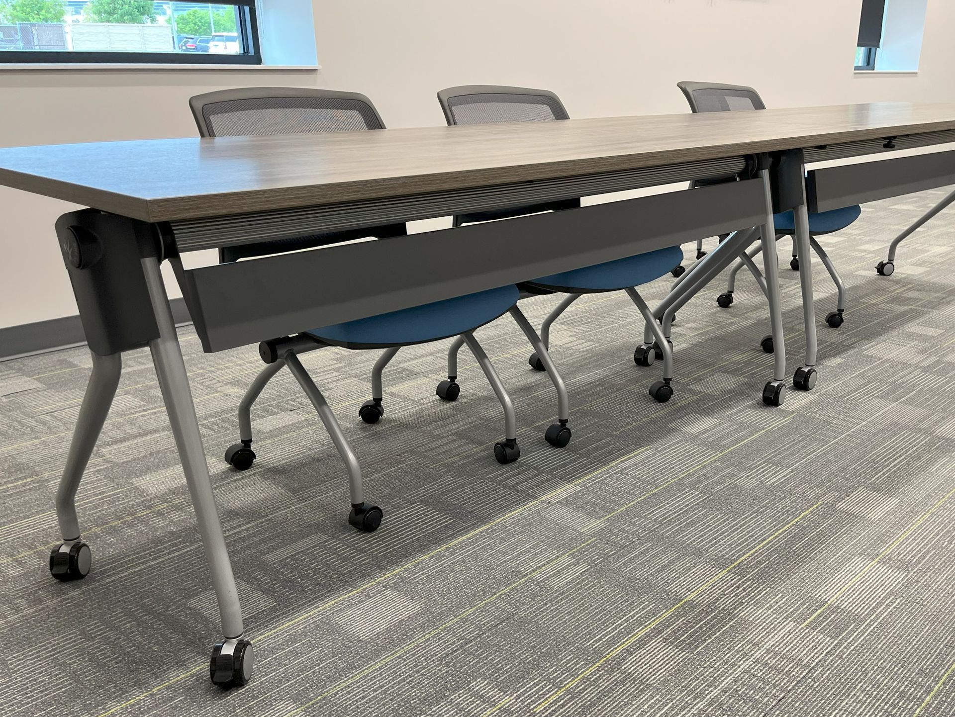 A waiting room with two pink arm chairs and multi-level side tables.