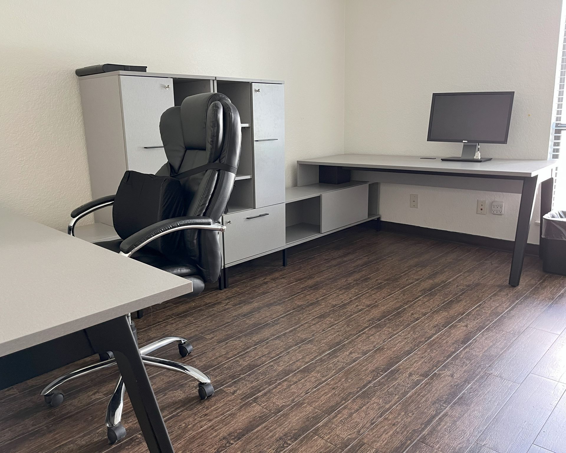 Two light gray desks facing opposite directions with mixed level storage along a shared wall. 