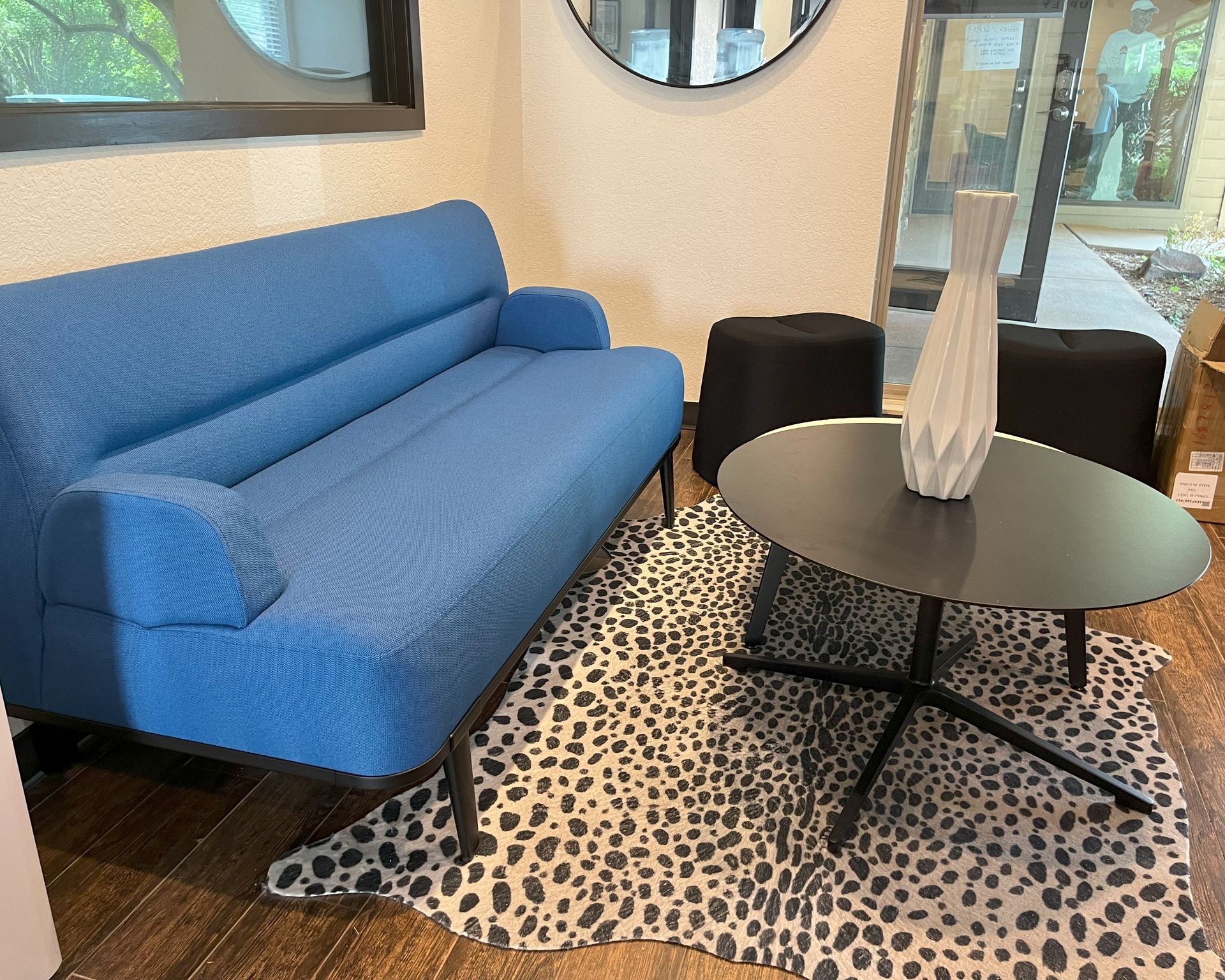 A blue couch and a black coffee table in a small office reception area.