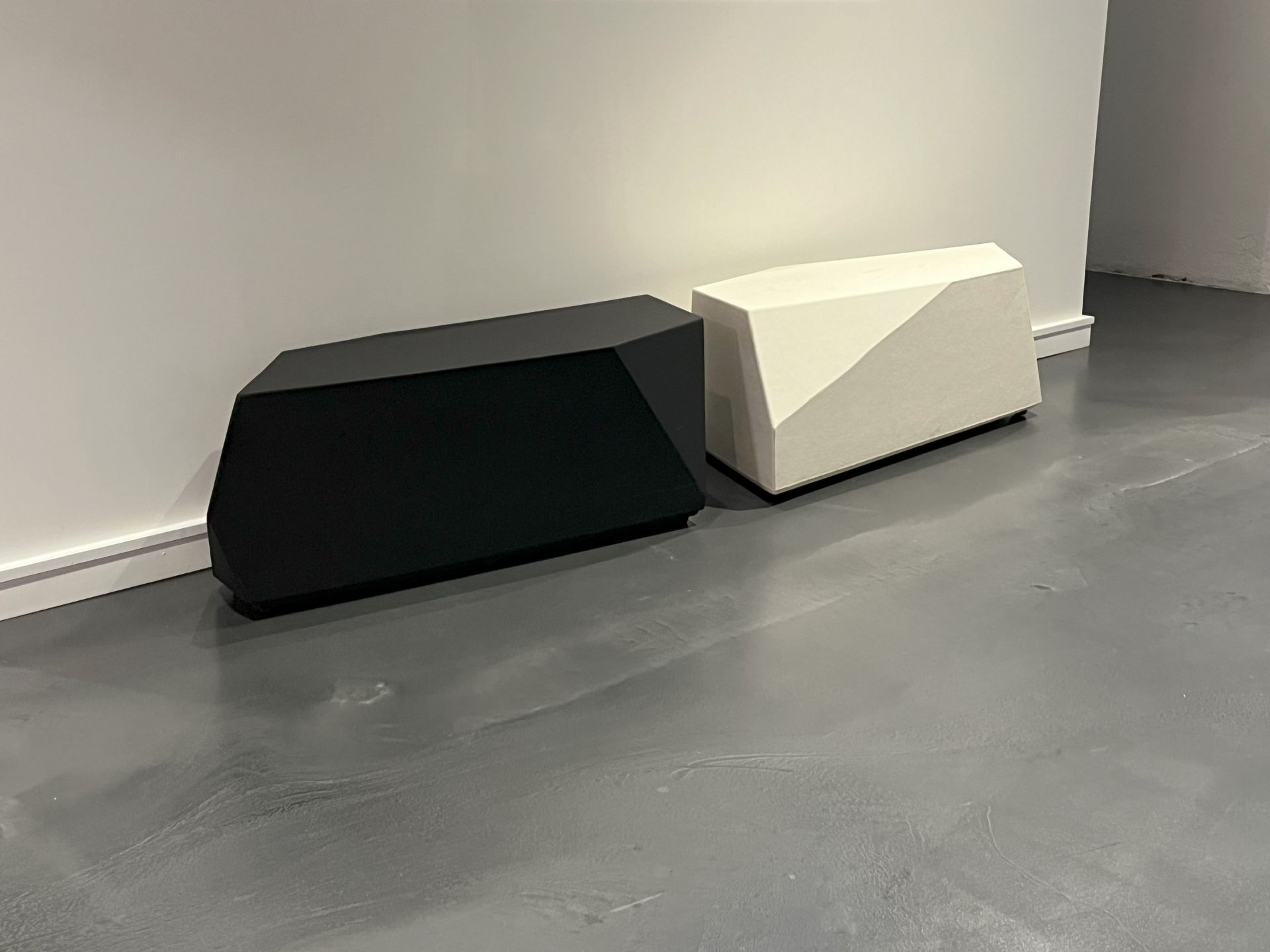 Two Rock Elements FlexPlus benches side by side, black on left, white on right, on concrete floor. 