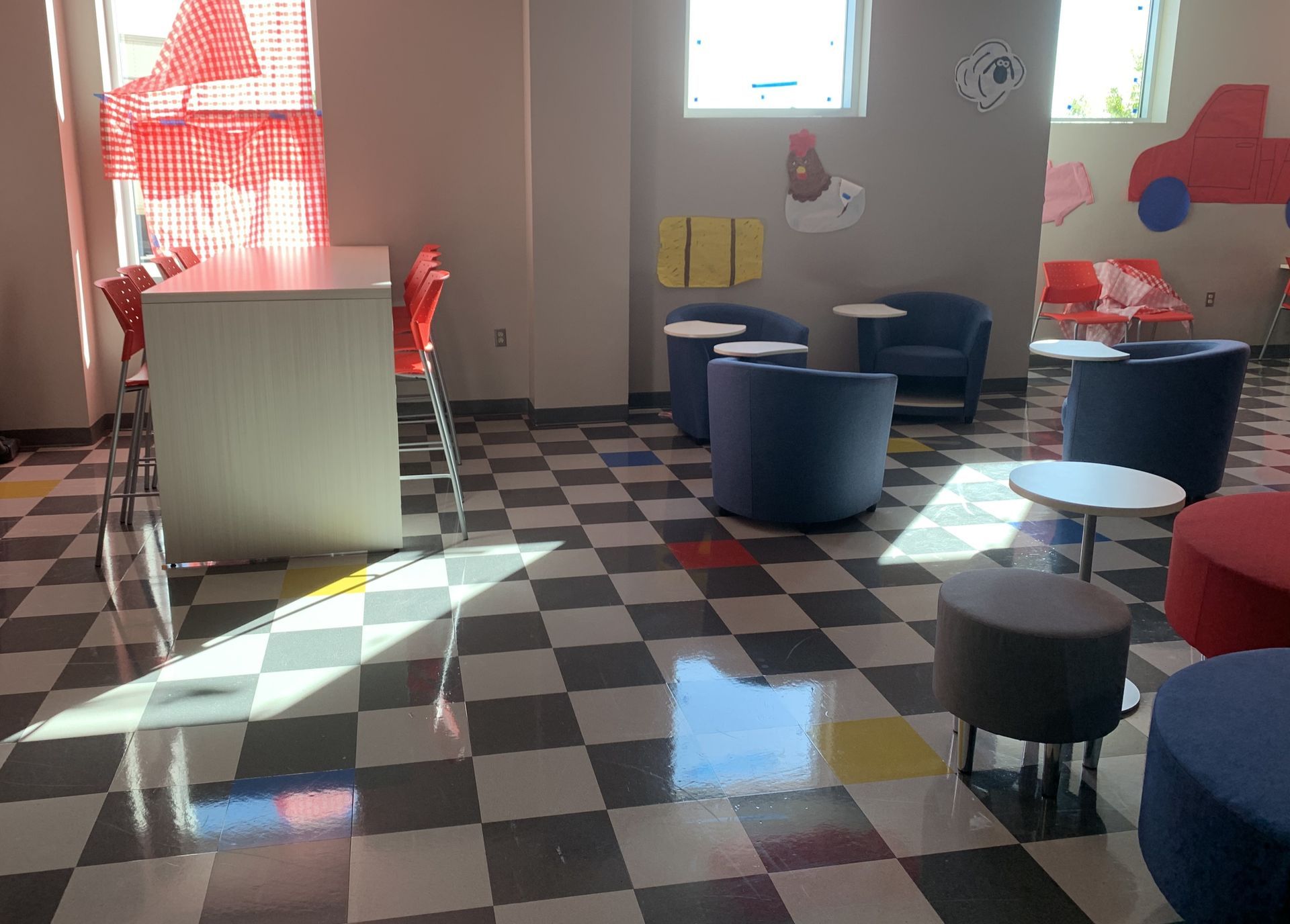 A room with a checkered floor and chairs and tables