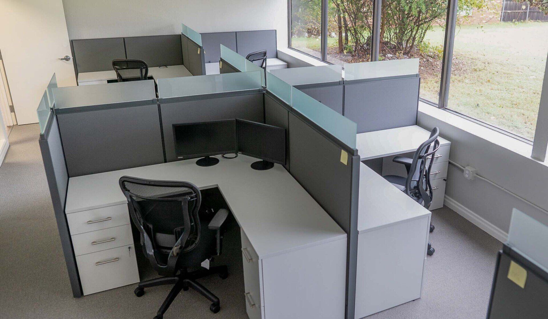 an office cubicle with a computer on the desk