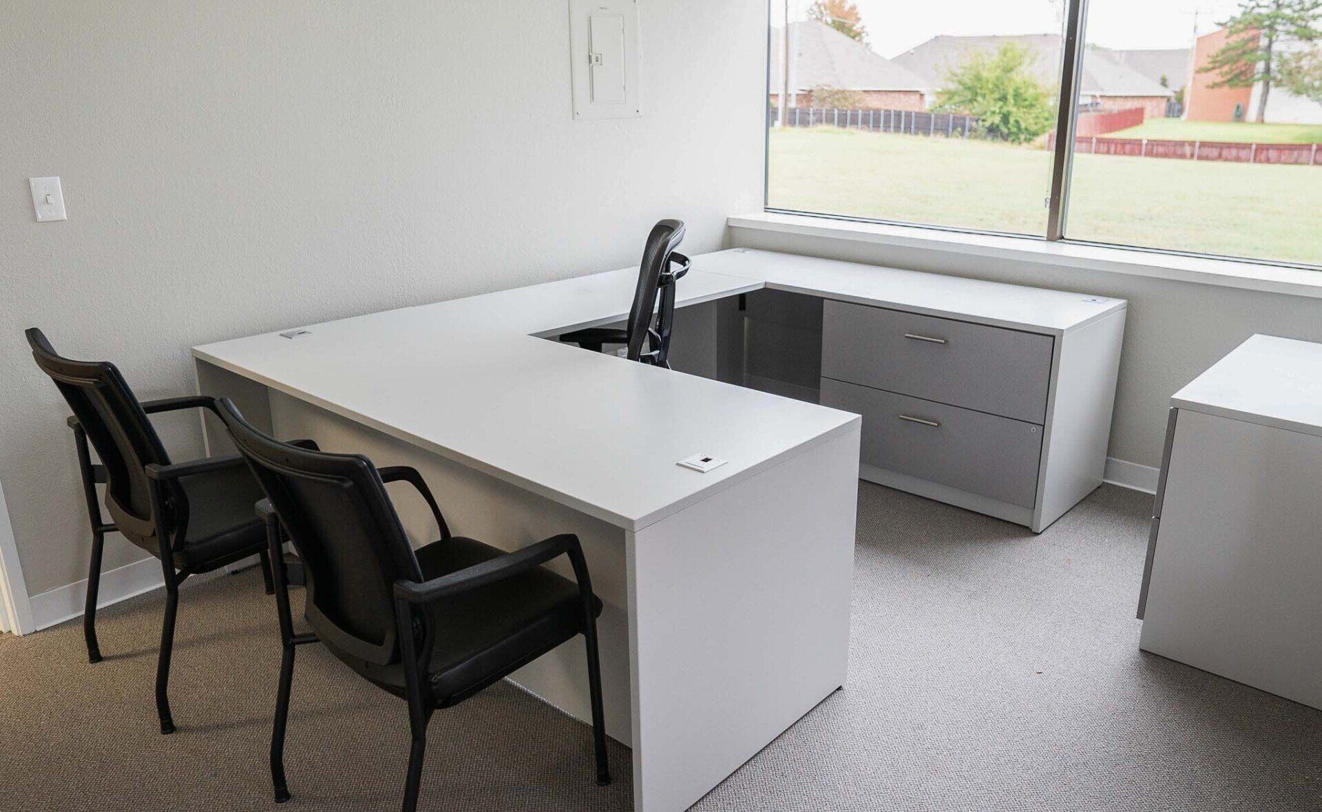 a small office with two chairs and a white desk