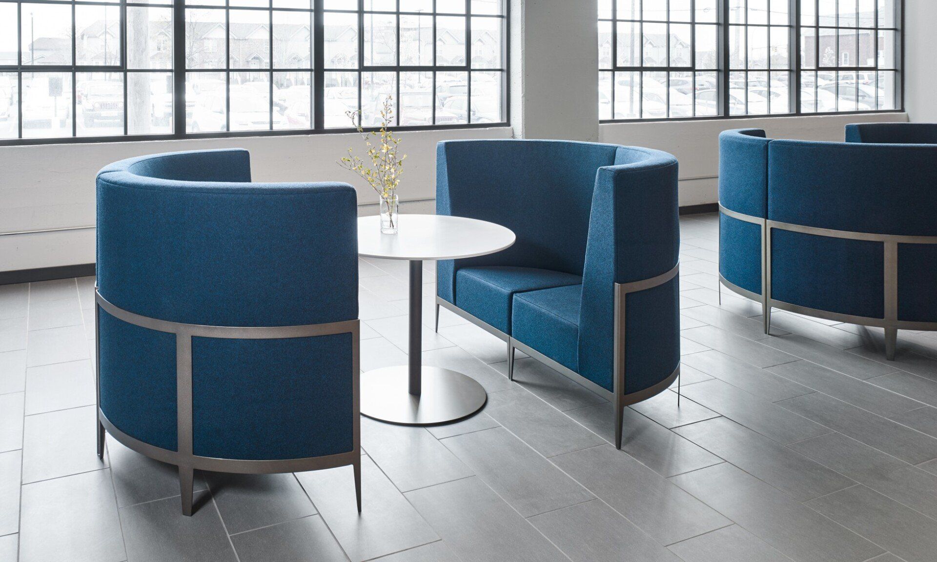 Curved blue privacy banquette loveseats with table between