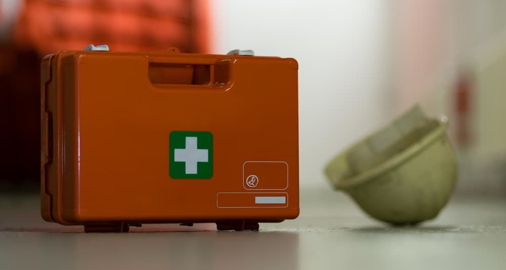 A First Aid Kit Is Sitting on A Table Next to A Helmet — Revive Training in Casino, NSW