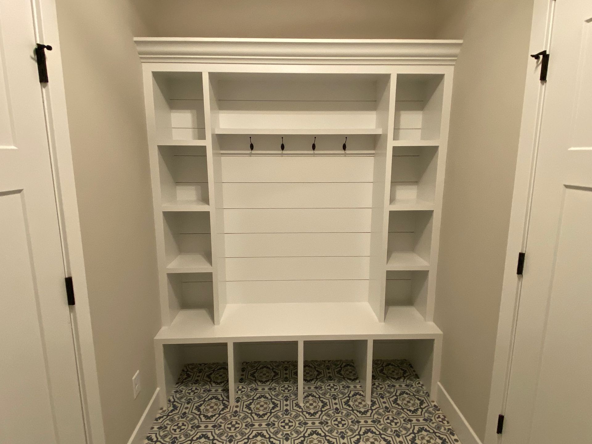 A hallway with a bench and shelves in it.