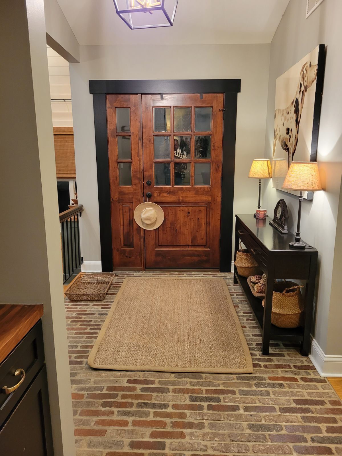 A hallway with a wooden door and a rug on the floor.