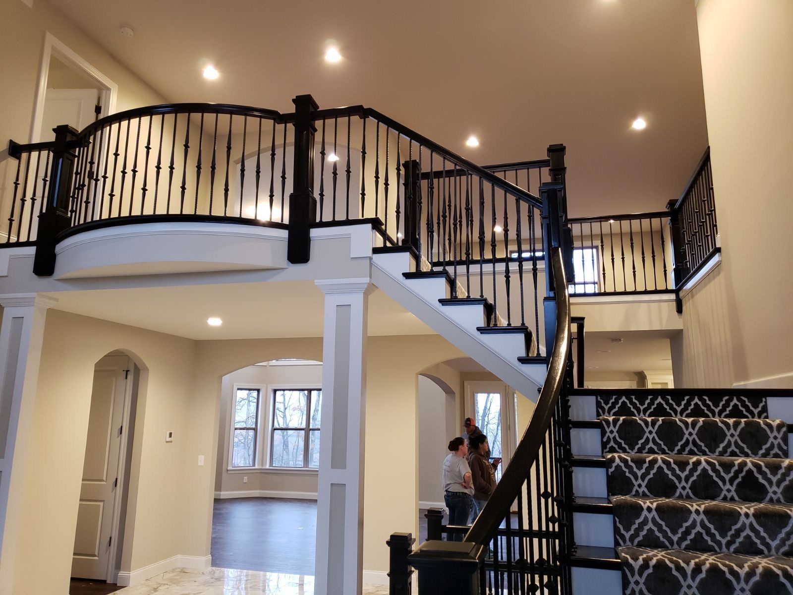 A man and woman are standing on the stairs of a house.