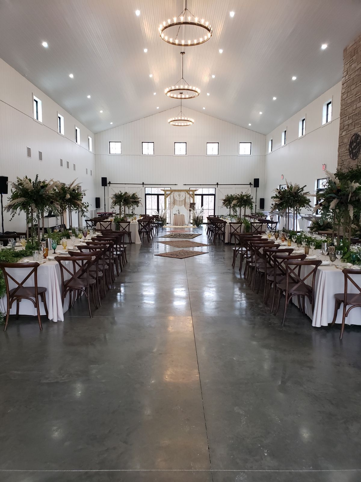 A large room with tables and chairs set up for a wedding reception.