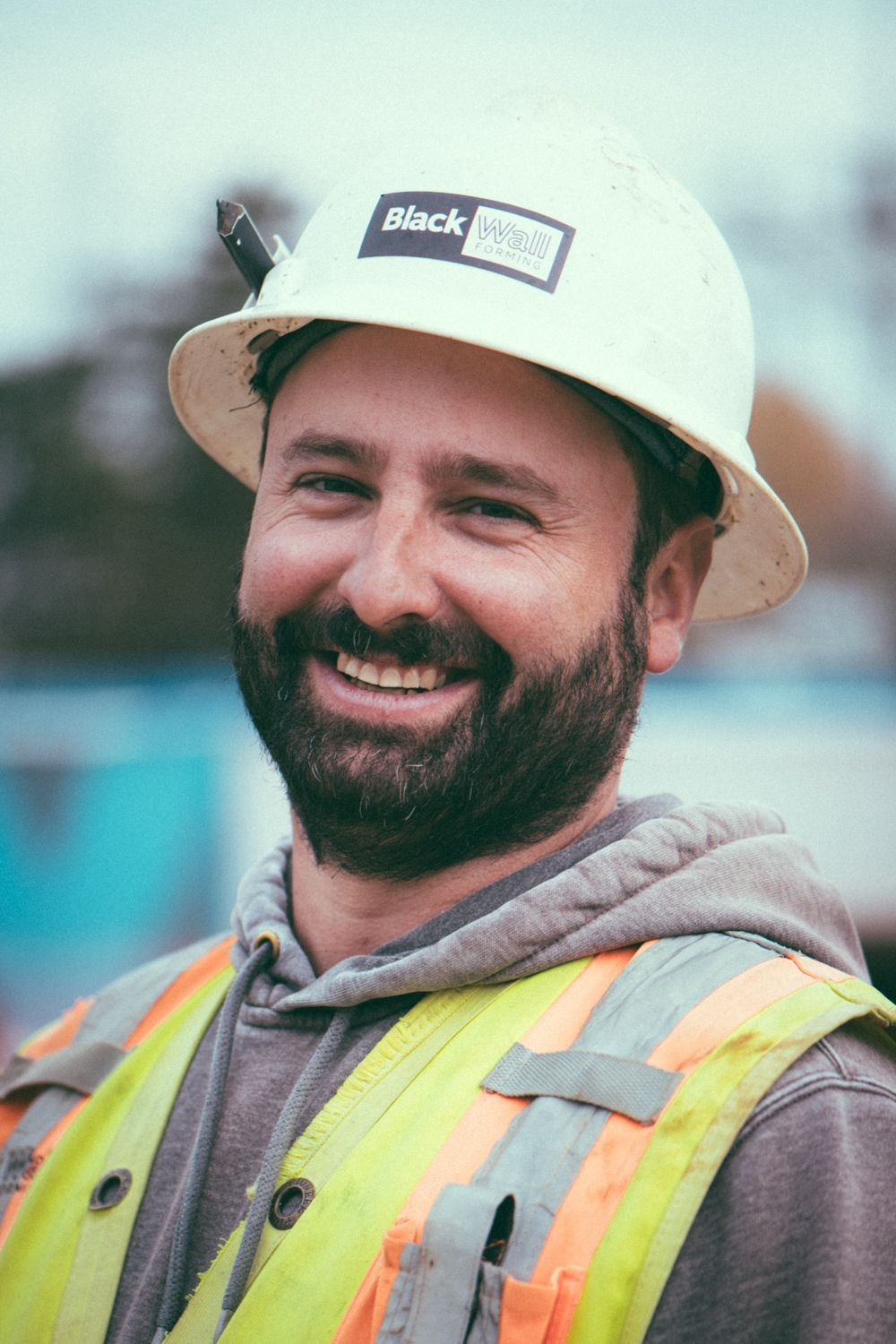 Smiling construction worker in hard hat and safety vest on a job site