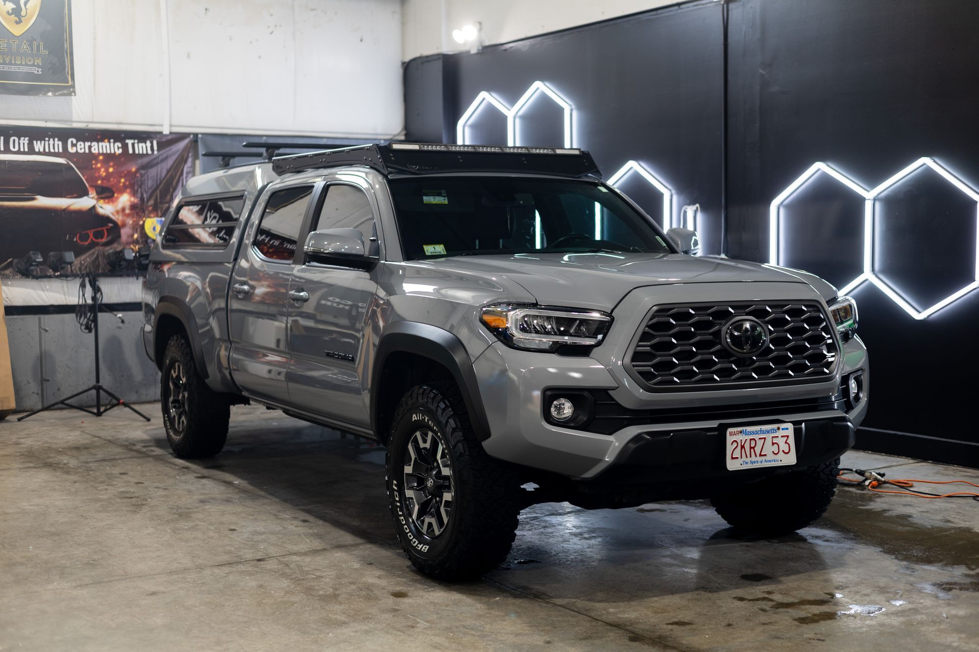 Dark gray BMW sedan parked in front of a building with black wheels and tinted windows.