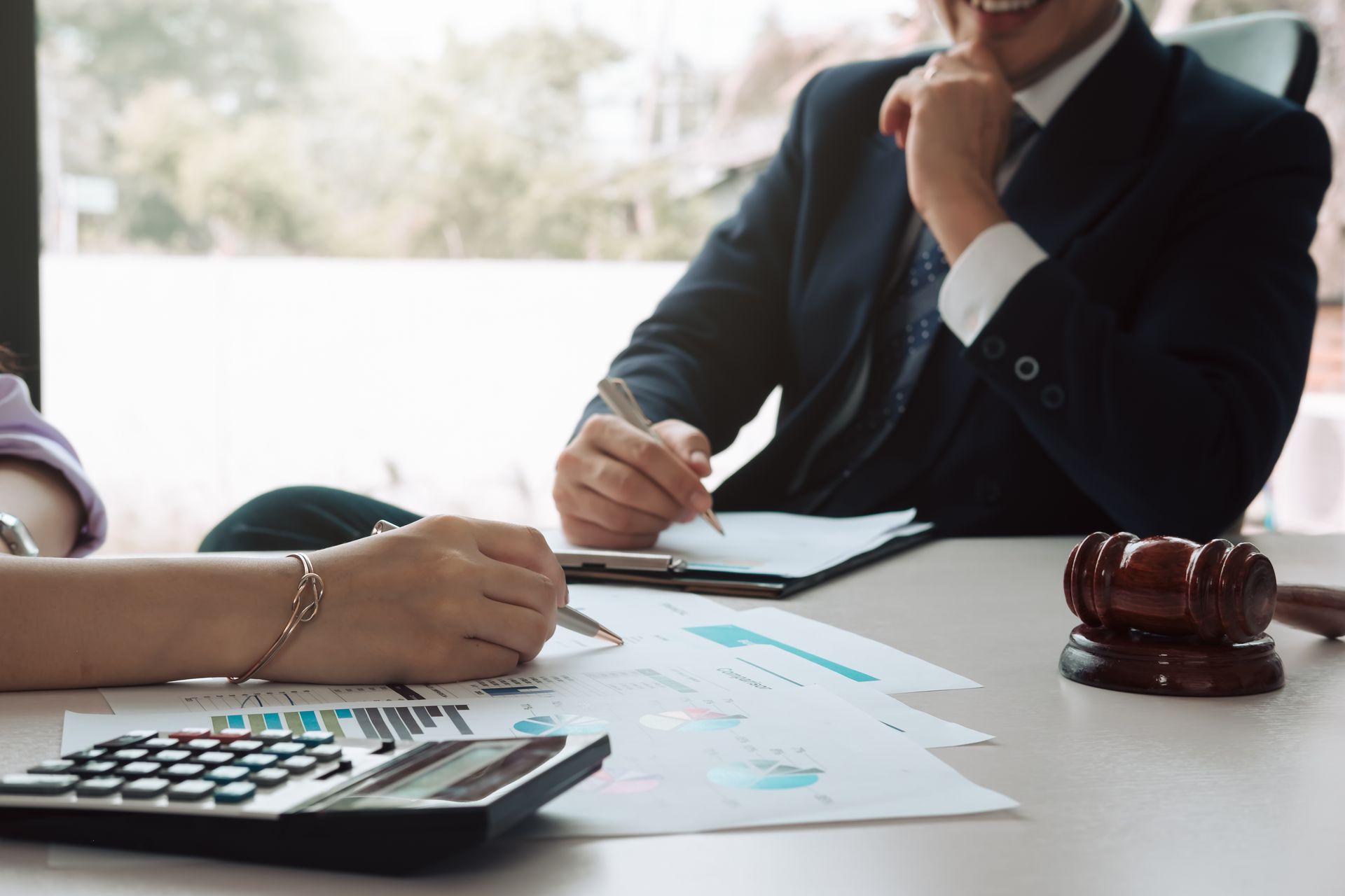 Un homme et une femme sont assis à une table avec une calculatrice et des papiers.