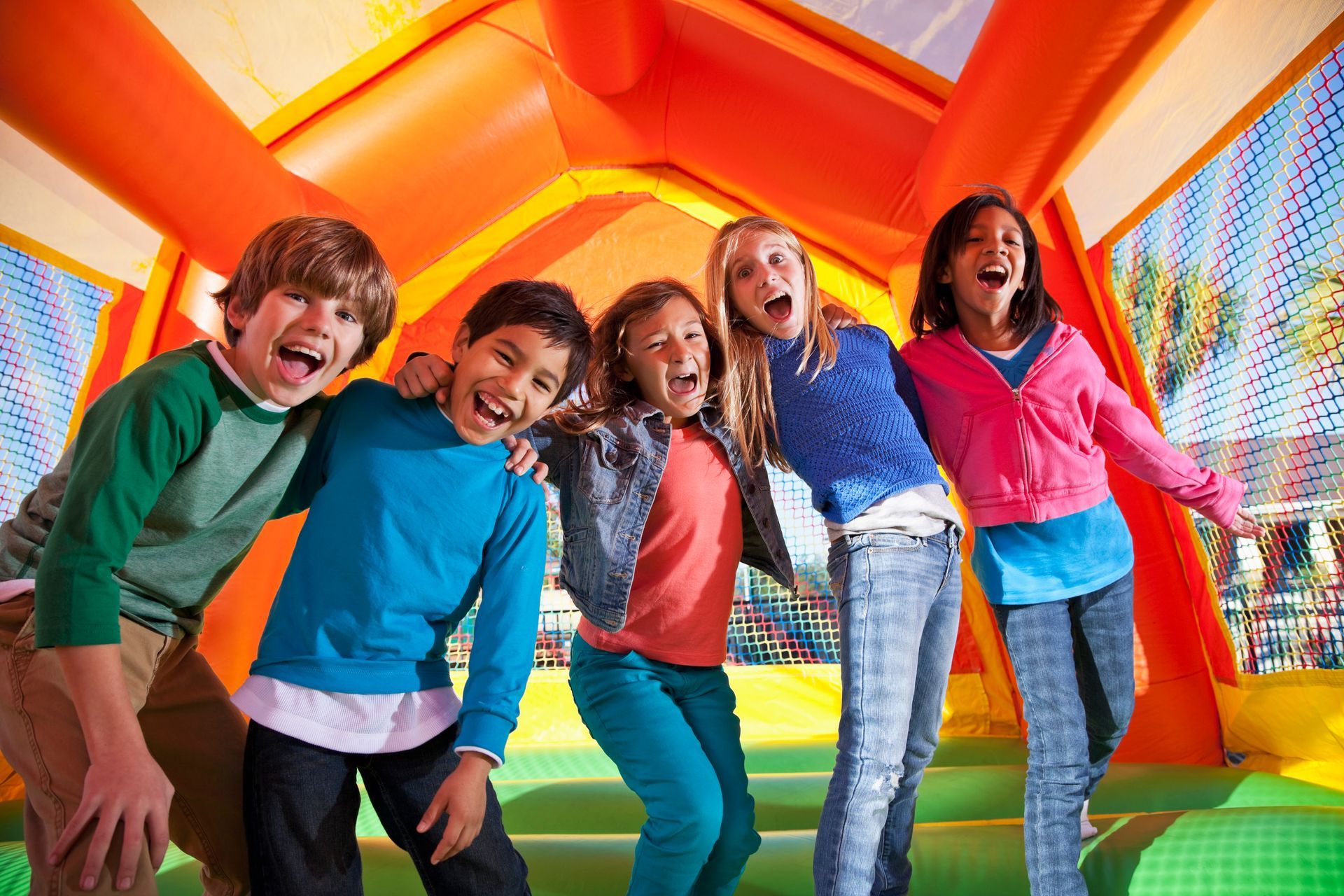 A group of children are posing for a picture in a bouncy house.