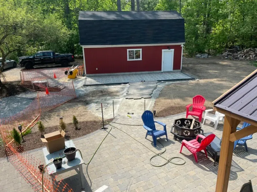 An aerial view of a backyard with a fire pit and chairs.