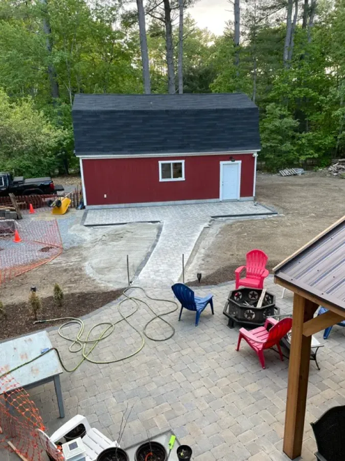 An aerial view of a backyard with a red barn and a fire pit.
