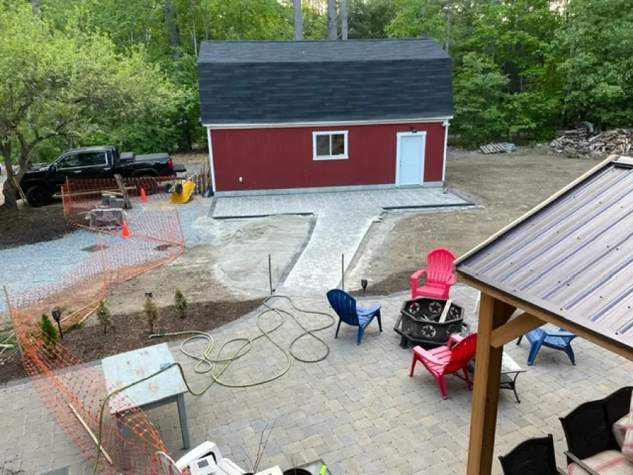 An aerial view of a backyard with a red barn and a fire pit.