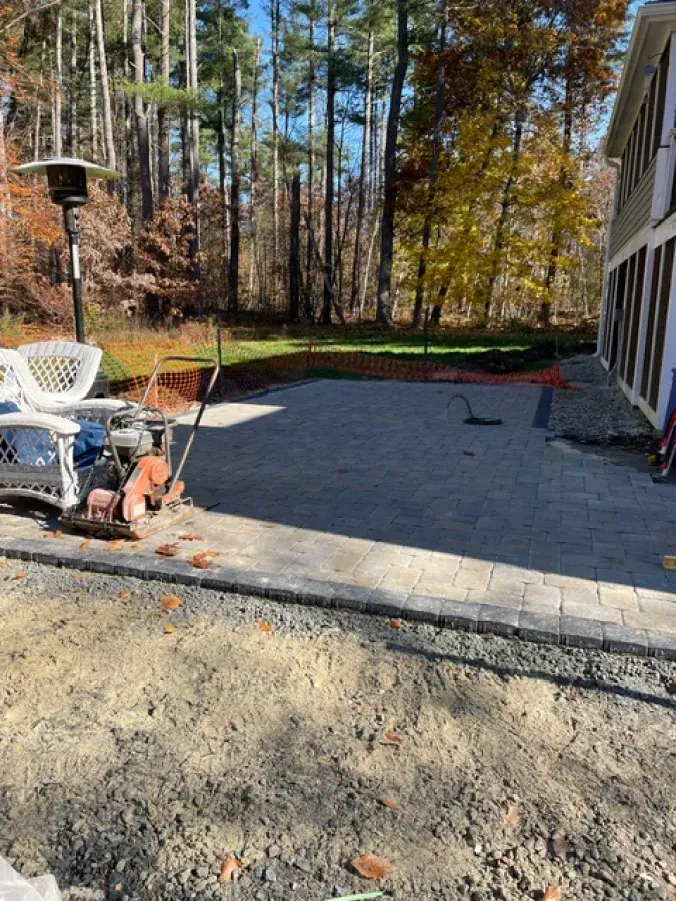 A patio is being built in the backyard of a house.