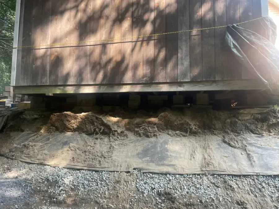 A wooden building is sitting on top of a pile of dirt.