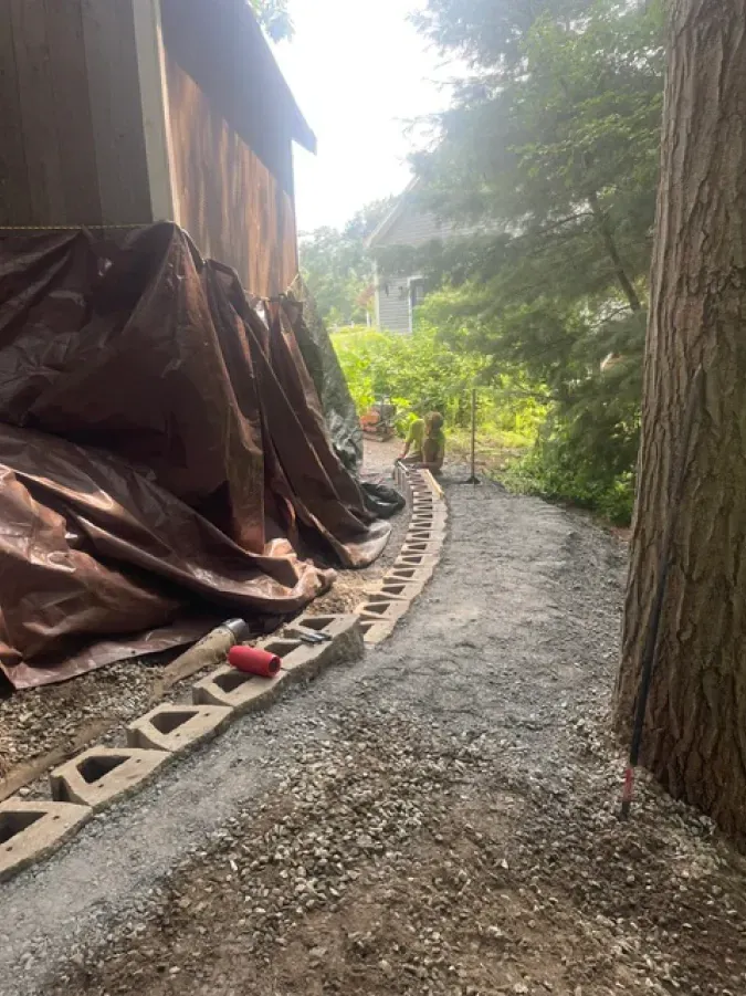 A dirt path leading to a house covered in tarps.