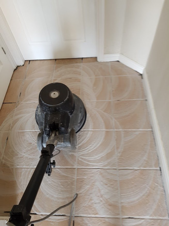 A tile floor is being cleaned with a machine.