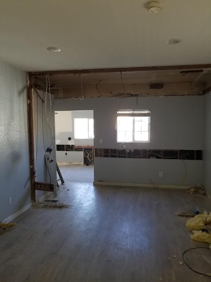 An empty room with a ladder hanging from the ceiling.