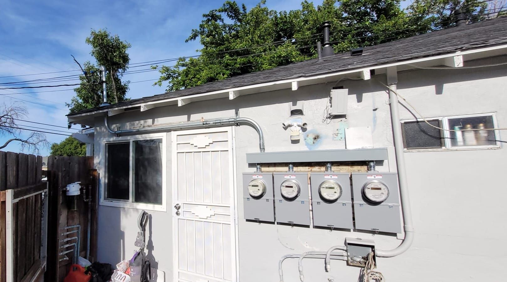 A shed with a lot of wires hanging from the side of it.