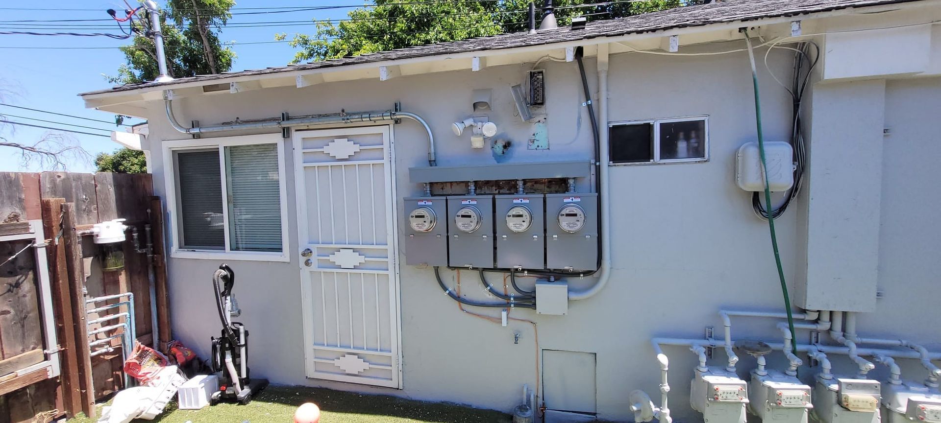 A white house with a lot of wires hanging from the side of it.