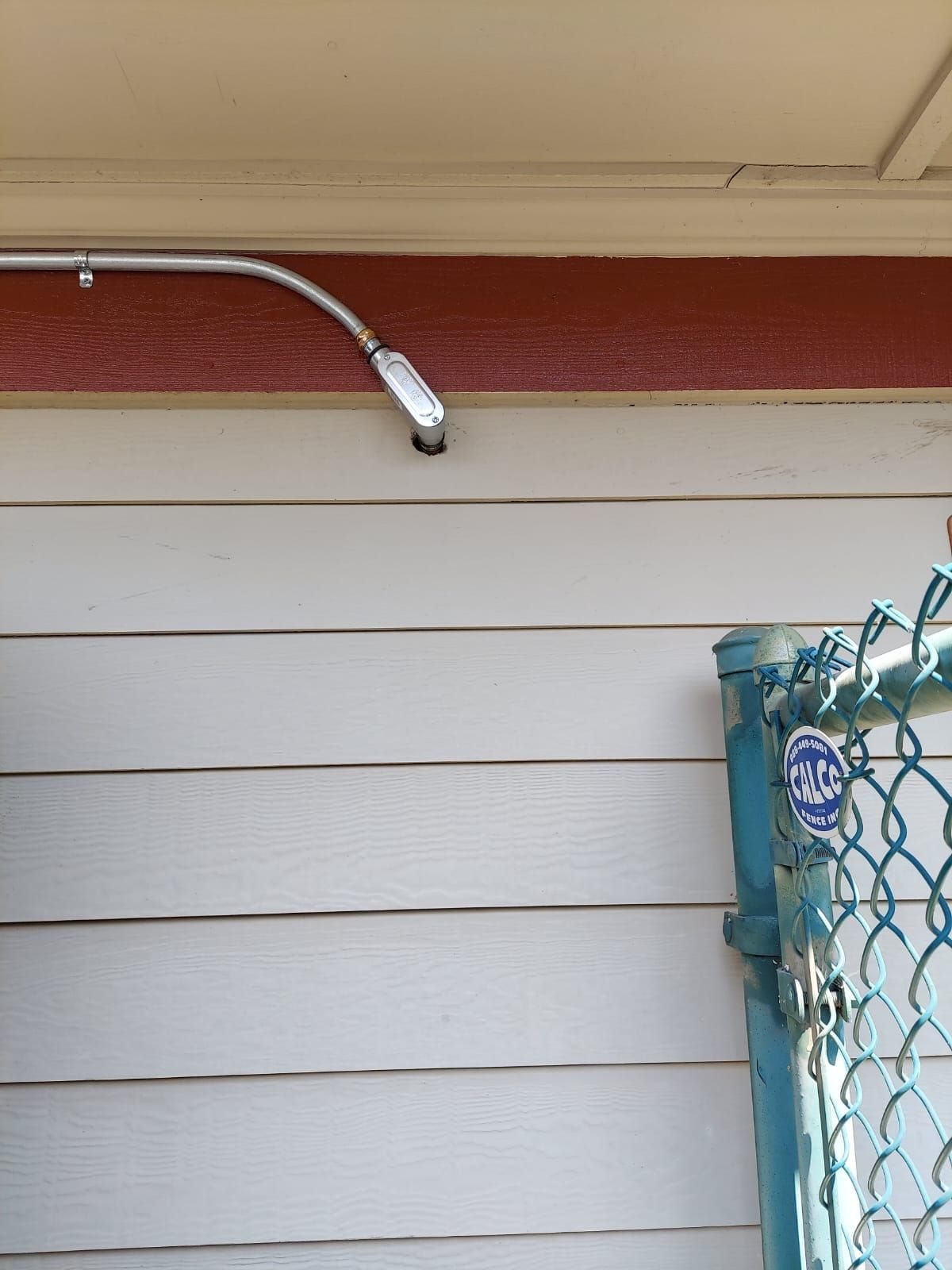 A white house with a blue chain link fence