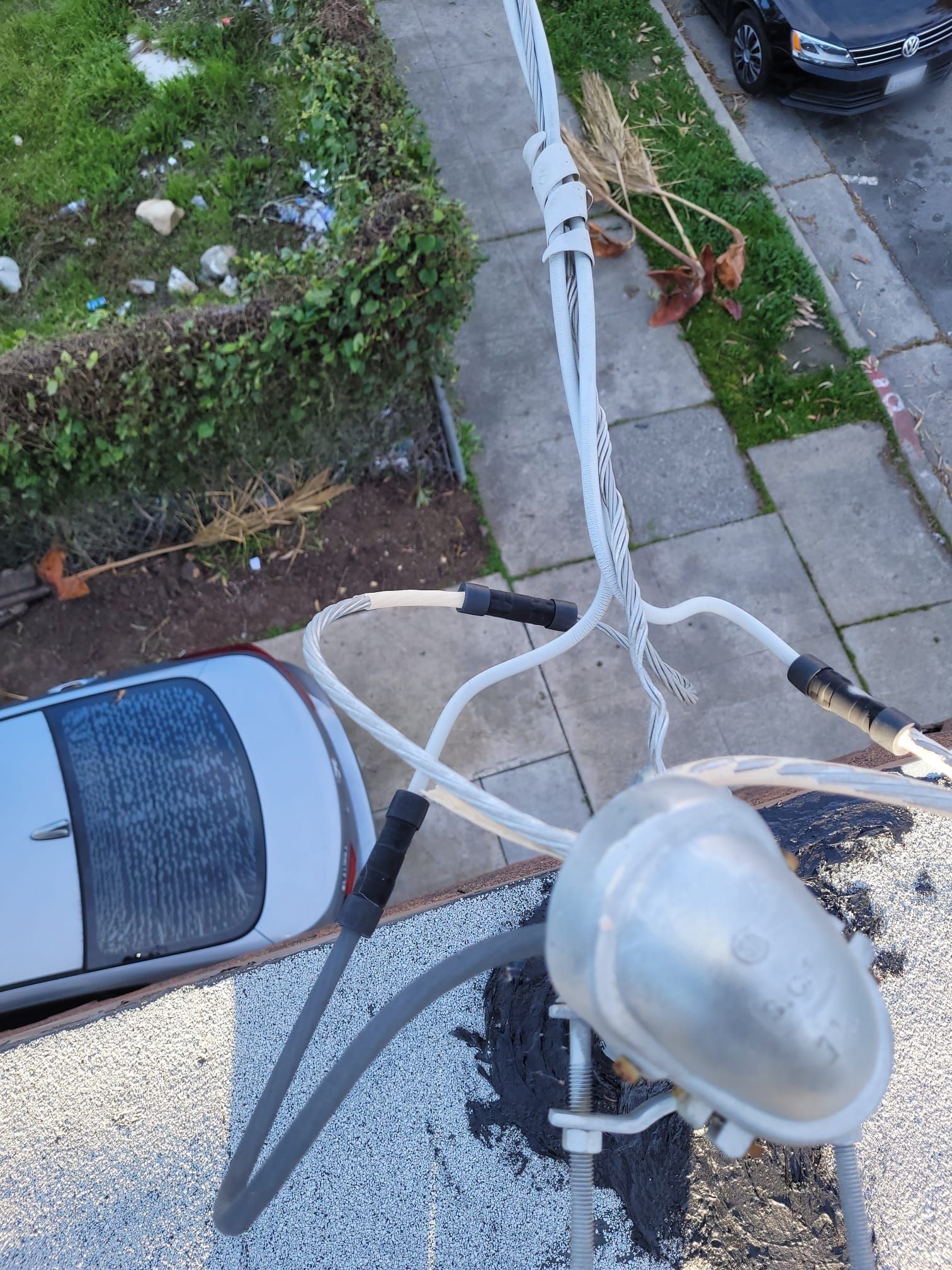 A car is parked on the side of the road next to a telephone pole.