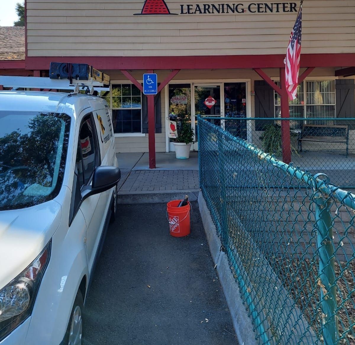 A white van is parked in front of the learning center